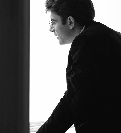 Man calmly looking out a window with a clear, focused gaze.